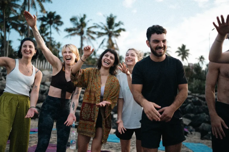 Students cheering and smiling together on the beach in Varkala